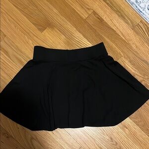 A black mid thigh skirt. H and M